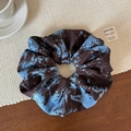 Detalle de coletero grande con estampado de mármol azul y marrón sobre fondo de madera - Coletero Grande Azul