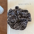 Dettaglio dell'elastico per capelli leopardato con trama del tessuto e pieghe eleganti - Leopardo Grigio