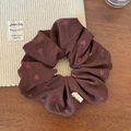 Detail of a brown scrunchie with red hearts and a white Hand Made label on a cozy wooden desk - Heart Style (FQ-0013) / Reddish Brown