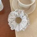 Nahaufnahme des französischen gepunkteten Scrunchies mit weichem Stoff und Vintage-Stil - Beige Gepunktet