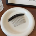 Detail showing elegant black top bar and silver metal U-shaped teeth of the hair comb - Black