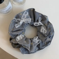 Détail du chouchou à carreaux avec nœuds en dentelle blanche et motifs à pois jaunes - Carreaux Noirs