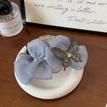Détail d'une pince à cheveux en organza bleu clair ornée d'un papillon en strass - Bleu 13cm