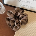 Detailed close-up of brown satin silk scrunchie with elegant pleated fabric texture - Brown