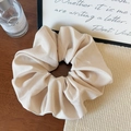 Detailed close-up of a beige fabric hair scrunchie showing fine texture and silk material - Off-white