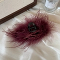 Detail showing fluffy burgundy ostrich feathers on a large claw clip with a sleek finish - 13cm / Burgundy