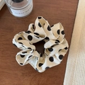 Close-up of cream scrunchie with large black polka dots on dark wood background - Off White