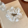 Vista dettagliata dell'elastico in chiffon bianco a pois con elegante ciondolo di perle - Anello per capelli con perla bianco sporco