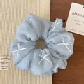 Dettaglio della trama dell'elastico in organza azzurro con fiocchi di nastro - Blu