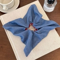 Detalle de coletero denim azul con forro de lunares rojos y blancos sobre un libro - Estilo Bufanda