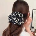 Détail d'un chouchou vintage français à fleurs blanches sur une coiffure demi-attachée - Pince à Queue de Cheval Imprimé Noir