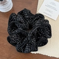 Détail d'un chouchou noir à motifs blancs sur bois et texture beige raffinée - Chouchou Noir 4 Couches