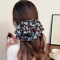 Détail d'une pince à cheveux à fleurs marron sur cheveux mi-attachés avec tissu plissé - Pince à Ressort Imprimé Bleu