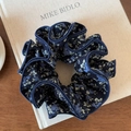 Vintage marineblauwe bloemen scrunchie met vierlaagse rand op een linnen boek - Marineblauw Bloemen