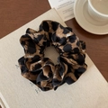 Detailed view of leopard print satin scrunchie with elegant black stitched edges - Coffee Leopard