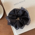 Detailed shot of black satin scrunchie with polka dot mesh lace on a vintage book - Single Layer Black Polka Dot