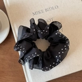 Detail view of black polka dot mesh scrunchie with pleated edges on a book prop - Double Layer Black Polka Dot