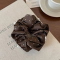 Dettaglio di scrunchie in raso marrone scuro con pois a cuore bianchi e perle applicate - Marrone