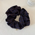 Dettaglio dell'elastico per capelli marrone a pois con ciondolo di perla - Pois Blu Notte