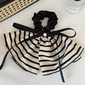 Dettaglio dello scrunchie a righe con ciondolo dorato e nastri di seta neri di alta qualità - Bianco Crema a Righe