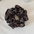Dettaglio di un elegante elastico in tessuto paisley con texture plissettata vintage - Fiore da Testa Nero Paisley