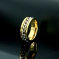 Detalle de anillo giratorio bicolor con cadena de acero sobre fondo negro elegante - US 10 / Dorado