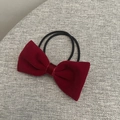 Détail d'un chouchou en velours rouge foncé avec doubles élastiques noirs sur tissu gris - Élastique Rouge Vin