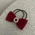 Gros plan détaillé d'un chouchou noeud en velours rouge foncé avec une boucle en strass brillant - Élastique à Cheveux Strass Rouge Vin
