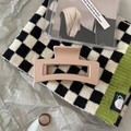 Detail of a matte Morandi pink rectangular hair claw clip on a stylish knitted scarf - Rectangular Hollow Style / Square Apricot