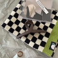 Detailed view of a large matte brown hair claw clip and an amber resin ring on a grid fabric - Hanger Coffee