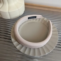 Detail shot of the cream fabric headband showing the handmade label on a ceramic plate - Light Skin