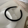 Dettaglio di un cerchietto minimalista in pelle PU nera con eleganti terminali in metallo oro - Nero