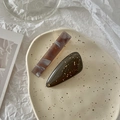 Detail of a vintage acetate marble hair clip and a brown resin clip with gold leaf flakes - Black Series