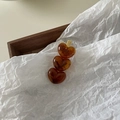 Gros plan de trois cœurs en acrylique ambre sur une pince à cheveux en métal doré brillant - Style Ambre (Ambre) / Marron