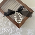 Détail d'un chouchou perles double couche avec un grand nœud en organza noir élégant - Noir
