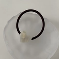 Detail view of a cream translucent heart resin ornament on a black elastic hair tie - Mermaid White