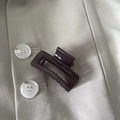Detail of a minimalist dark brown rectangular hair claw clip on a beige suit fabric - Dark Gray Rectangle