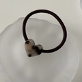 Detalle de un coletero para el pelo con corazón de carey sobre una bandeja blanca - Carey Claro
