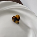 Detail of a mini heart hair claw clip with classic tortoiseshell texture on a white plate - Dark Tortoiseshell