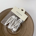 Dettaglio di quattro fermagli per capelli in metallo bianco minimalisti in confezione - Bianco