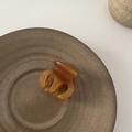Vista macro detallada de la pequeña pinza para el cabello de acetato ámbar con textura pulida - Café Claro