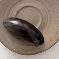 Détail de la barrette à motif écaille avec lettrage doré sur une assiette en céramique - Marron