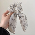 Detail of grey organza scrunchie with floral butterfly pattern and pearl ribbon drops - Apricot