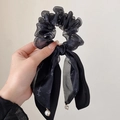 Detail of black tulle scrunchie with long ribbons and elegant white pearl pendants - Black