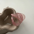 Primer plano de pinza de pelo rosa translúcida con diseño de dientes grandes en bandeja - Rosa