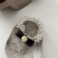 Detailaufnahme von Perlhaargummi mit schwarzer Schleife und Kamelienblüte - Perle Kamelie (Shan Cha Hua) / Weiß