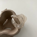 Primer plano de pinza para el pelo ámbar transparente con muelle metálico y diseño hueco - Champaña
