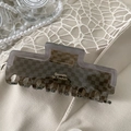 Detail of dark brown checkerboard hair claw clip with Barrette la France logo lettering - Gray Check-Outlined Rectangle