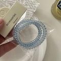 Detail view of light blue spiral telephone wire hair ties on a white accessory card - Spiral Hair Ties Set / Blue