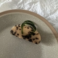 Gros plan sur une pince à cheveux léopard avec détail de poignée vert émeraude - Écaille Claire